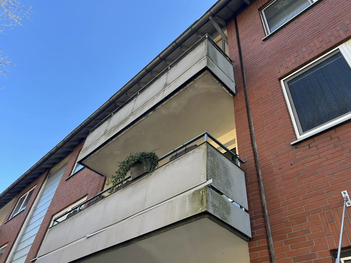 Mehrfamilienhaus in Gelsenkirchen mit sanierten Balkonen, Ansicht von unten gegen den Himmel