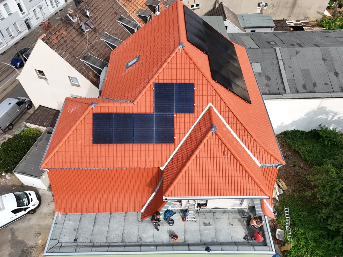 Frisch eingedecktes rotes Ziegeldach mit Photovoltaikmodulen in Bochum aus der Luft