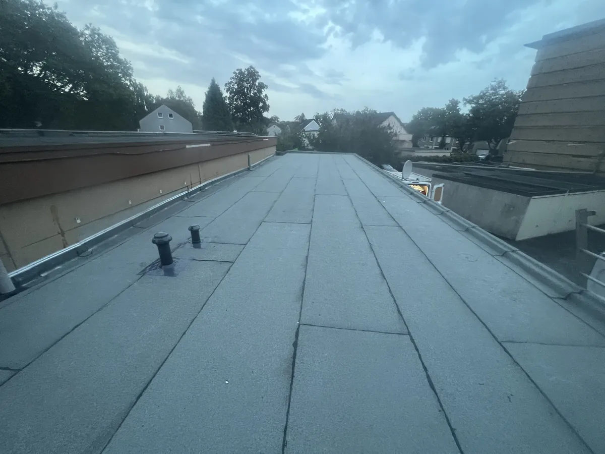Frisch abgedichtetes Flachdach mit Bitumenbahnen und Attikaabschluss in Herne