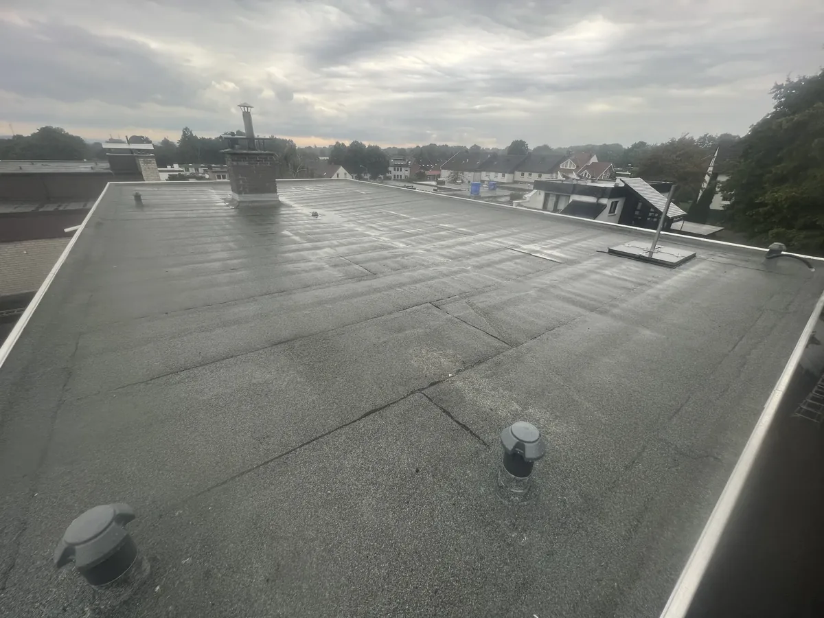 Großflächiges saniertes Flachdach mit Schornstein und Dachaufbauten in Herten
